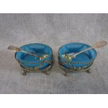A PAIR OF WHITE METAL OPENWORK SALTS with claw feet and blue glass liners and two silver mustard