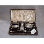 WALKER & HALL, SHEFFIELD: A CRUET SET with blue glass liners, in a fitted presentation case