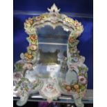 A CONTINENTAL FLOWER ENCRUSTED PORCELAIN FRAMED WALL MIRROR, 50cm high, 30cm wide