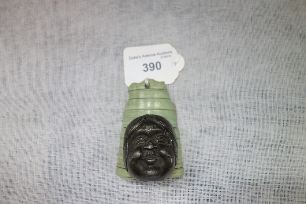 A JAPANESE BRONZE AND IVORY DESK ORNAMENT, the ribbed ivory with attached bronze head, 7 cms long