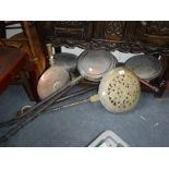 AN 18TH CENTURY WARMING PAN with a pierced lid and brass handle and a collection of similar