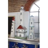 A LARGE PAINTED TIN STUDY OF A LIGHTHOUSE with steps and a balcony and two others similar (3)