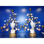 A PAIR OF CANDELABRA, with white crackle-glazed ceramic birds surrounded by flowers on a brass