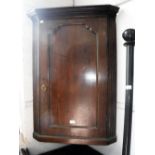 A GEORGE III OAK HANGING CORNER CUPBOARD