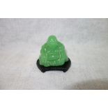 AN ORIENTAL GREEN GLASS STUDY OF BUDDAH, 6 cm high