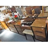 A 1960'S WALNUT AND EBONISED 'STAG' PART BEDROOM SUITE, comprising dressing table and stool, 122