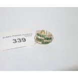 A GREEN AND WHITE STONE DRESS RING, four bands joined as one, on unmarked yellow metal, ring size M