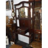 AN EDWARDIAN MAHOGANY HALL STAND with carved decoration and an oak display cabinet with leaded