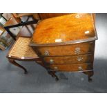 A REPRODUCTION WALNUT BEDSIDE CHEST 46 cm wide, and a mahogany stool with caned seat