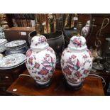 A PAIR OF TABLE LAMPS in the form of lidded vases decorated with flowers and birds on wooden