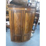 A GEORGE III FIGURED MAHOGANY BOWFRONTED HANGING CORNER CUPBOARD with green painted interior, 78 cms