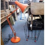 A VINTAGE ORANGE ANGLEPOISE LAMP and a 1950s wire magazine stand, with red ball finials (after