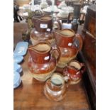 A SET OF FOUR GRADUATED STONEWARE HUNTING JUGS and a similar Doulton Lambeth jug (5)