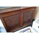 AN ARTS AND CRAFTS STYLE WALNUT HANGING TWO DOOR CUPBOARD, the doors carved with birds in an oak