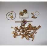 A 9 CT YELLOW GOLD CHARM BRACELET, with attached gold and yellow metal charms, and a collection of