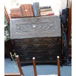 A GEORGE III OAK BUREAU, with allover carving, 97 cm wide