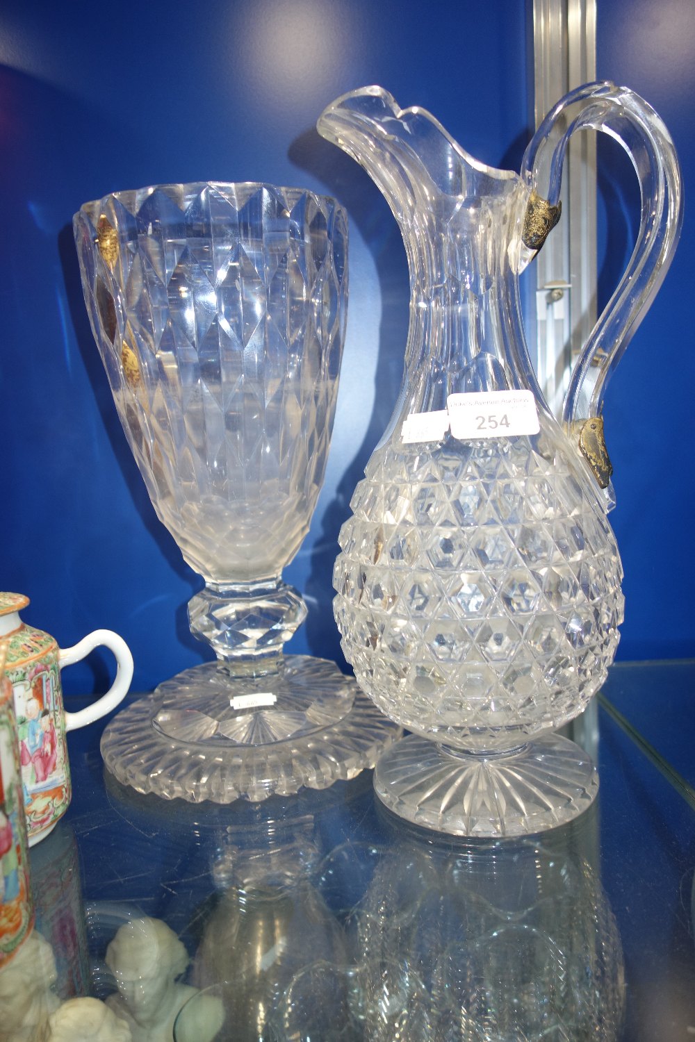 A 19TH CENTURY CUT GLASS JUG with gilt metal repair mounts to the handle and a similar vase