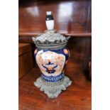 A 19TH CENTURY OIL LAMP, with spelter fittings and Imari style ceramic centre, 27.5 cm high (