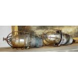 A PAIR OF VINTAGE INDUSTRIAL LAMPS, with aluminum bodies and wire covered glass domes 44cm high
