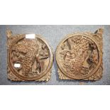 A PAIR OF ORIENTAL HARDWOOD CARVINGS of figures with trees, within circular panels, 19.5cm wide