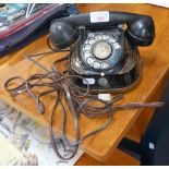 A VINTAGE BELL TELEPHONE with a black and gilt case and brass folding handle