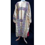 AN ECCLESIASTICAL ROBE IN GOLD LAME decorated with ecclesiastical style banded ribbon in gold,