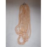 A SEVEN STRAND GRADUATED PEARL NECKLACE with ring and 'T' bar clasp