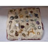 A COLLECTION OF VINTAGE BROOCHES mounted on a cushion