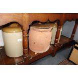 A 19TH CENTURY TERRACOTTA STORAGE JAR with a wooden lid and two stoneware jars with lids (3)