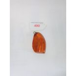 AN 'AMBER' PENDANT, of translucent orange colour, c.55mm x 35mm, c.18.7gm