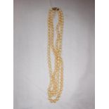 A DOUBLE STRAND CULTURED PEARL NECKLACE, each champagne pearl individually knotted, terminated in