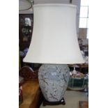 A CHINESE STYLE GLAZED CERAMIC TABLE LAMP decorated with blossoms on a grey grou