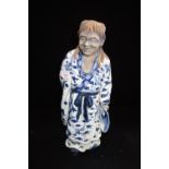 A CHINESE BLUE AND WHITE GLAZED STUDY OF AN ELDER MAN in a dressing robe,