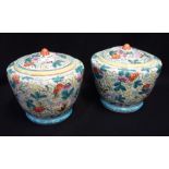 A PAIR OF CHINESE JARS AND COVERS, brightly painted with plants and butterflies, each 23cm high