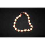 A SIMULATED PEARL AND CORAL NECKLACE