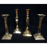 A PAIR OF 19TH CENTURY CORINTHIAN COLUMN BRASS CANDLESTICKS and another pair