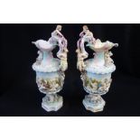 A PAIR OF 19TH CENTURY PORCELAIN EWERS elaborately moulded with putti and mythological creatures