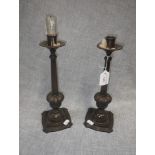 A PAIR OF PATINATED BRONZE CANDLESTICKS, on shaped spreading bases with moulded knops and tapering