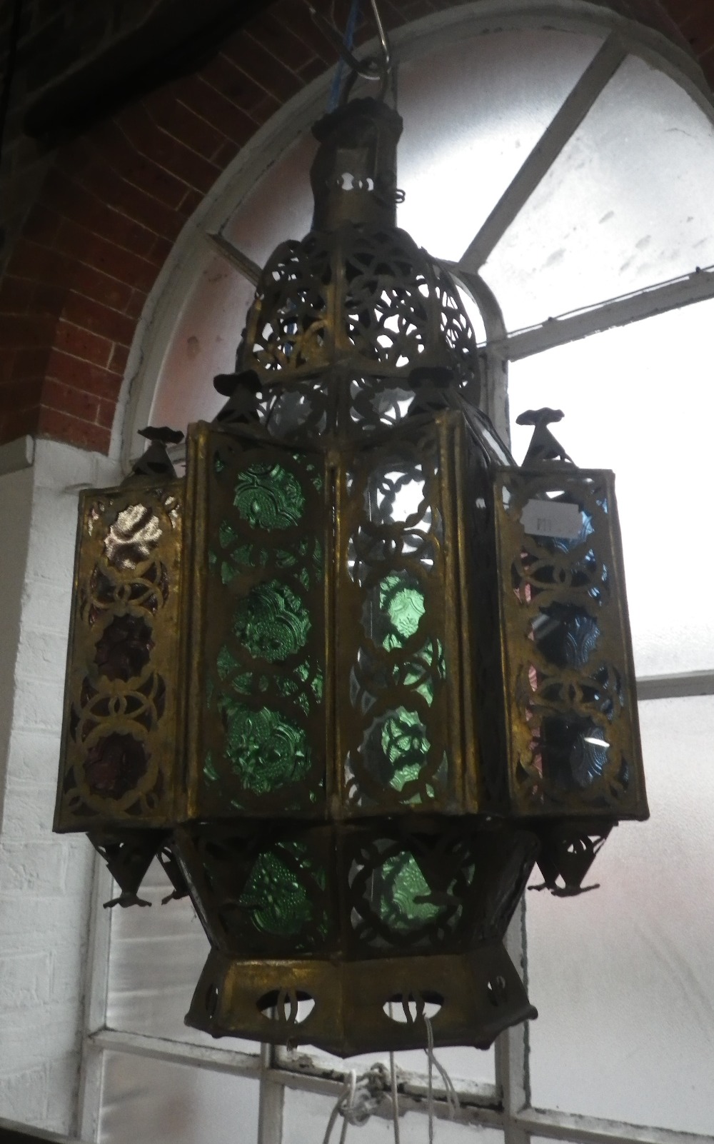 A MOROCCAN BRASS AND COLOURED GLASS STAR SHAPED HALL LANTERN