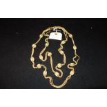YVES SAINT LAURENT: A multi-stranded yellow metal necklace, the clasp with attached Yves Saint