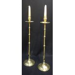 A PAIR OF EARLY 20TH CENTURY TALL BRASS CANDLESTICKS of elongated baluster form, 55cm high