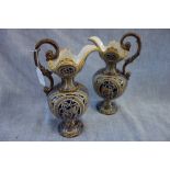 A PAIR OF CONTINENTAL MOULDED AND COLOURED EARTHENWARE EWERS with scrolling handles, 29cm high