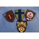 A PAINTED AND GILT OAK MOUNTED ARMORIAL SHIELD by A.W. Crisp & Co., Cambridge and three similar