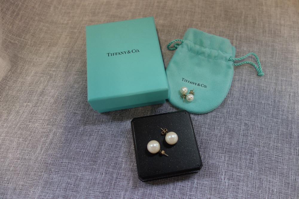 TIFFANY & CO: A pair of pearl ear studs, with 9ct yellow gold backs in a fitted pouch and