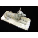 AN ART DECO PATINATED SPELTER STUDY OF AN ALSATIAN on an onyx and black base, 19cm long