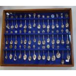 A QUANTITY OF COLLECTOR'S SPOONS in a glazed display cabinet