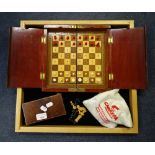 AN EARLY 20TH CENTURY STAINED BONE TRAVELLING CHESS SET, a bag containing wooden chess pieces and an