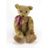 Vintage golden straw filled teddy bear with jointed limbs and beaded glass eyes, 63cm high Further