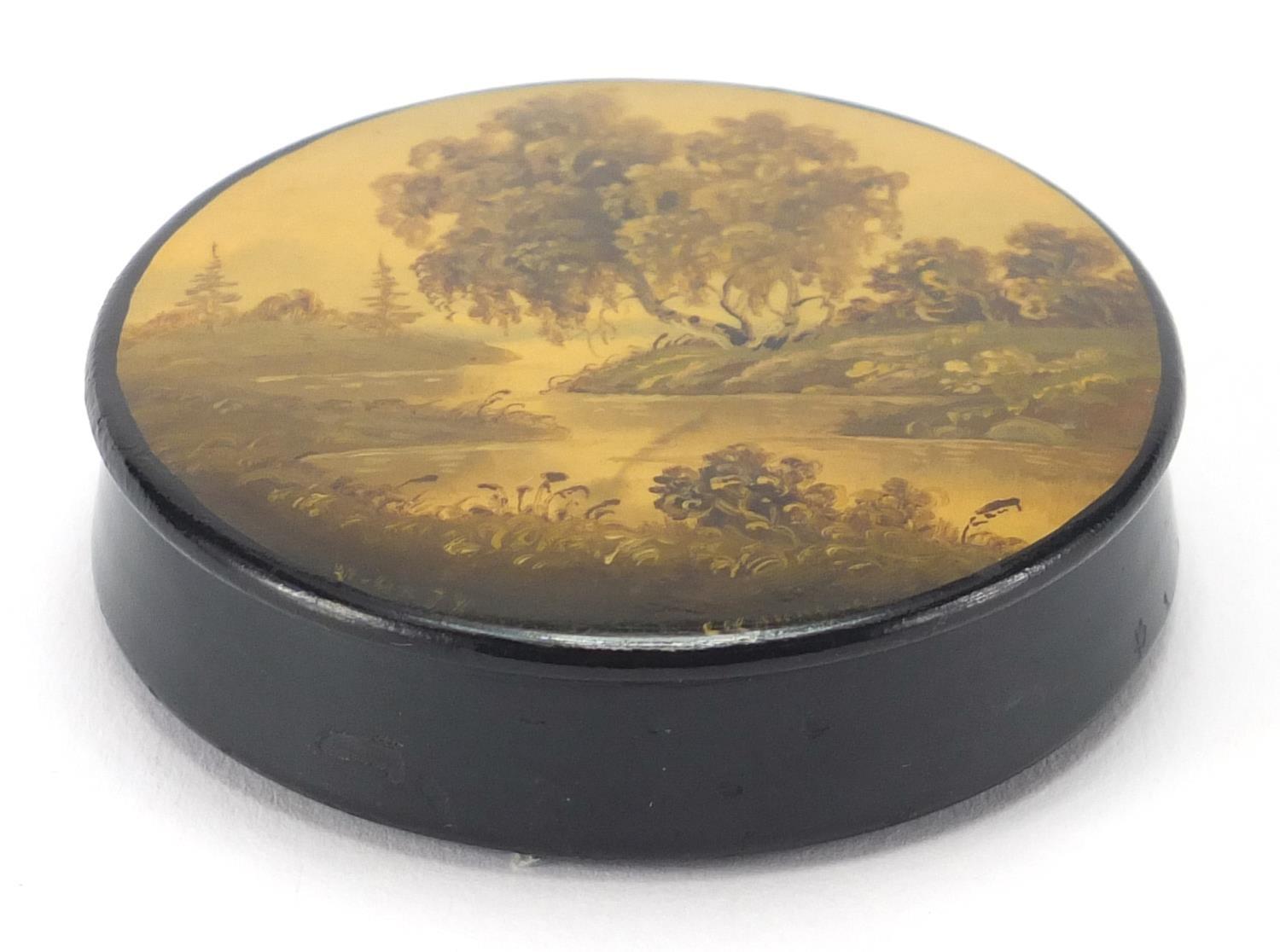 Russian lacquered snuff box, the lid hand panted with a river, indistinctly titled and inscribed