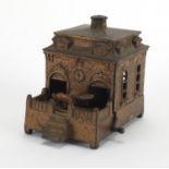 Novelty cast iron money box in the form of a dog rotating in and out of a house, 14cm in length